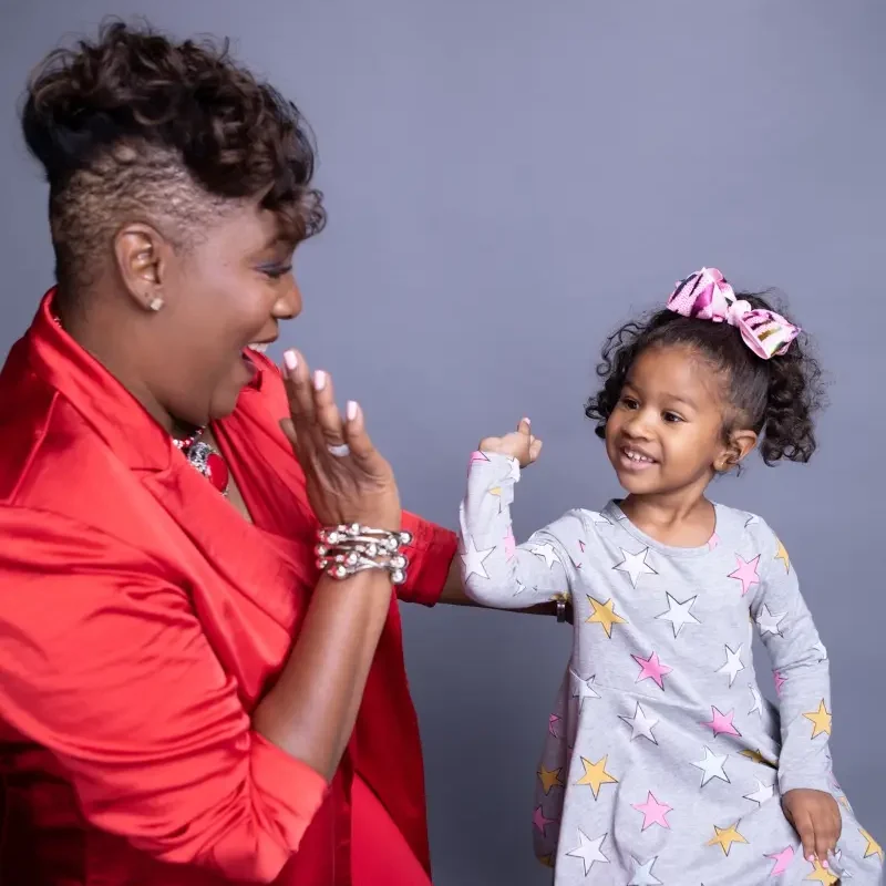 A woman giving a high-five to a little girl