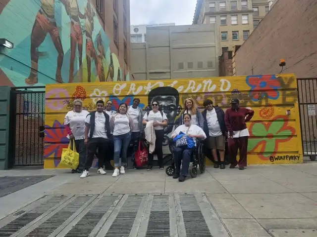 Goodfellas staff in front of mural